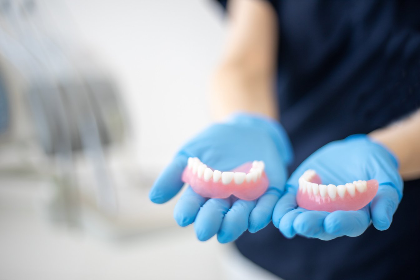 Dentist holding denture